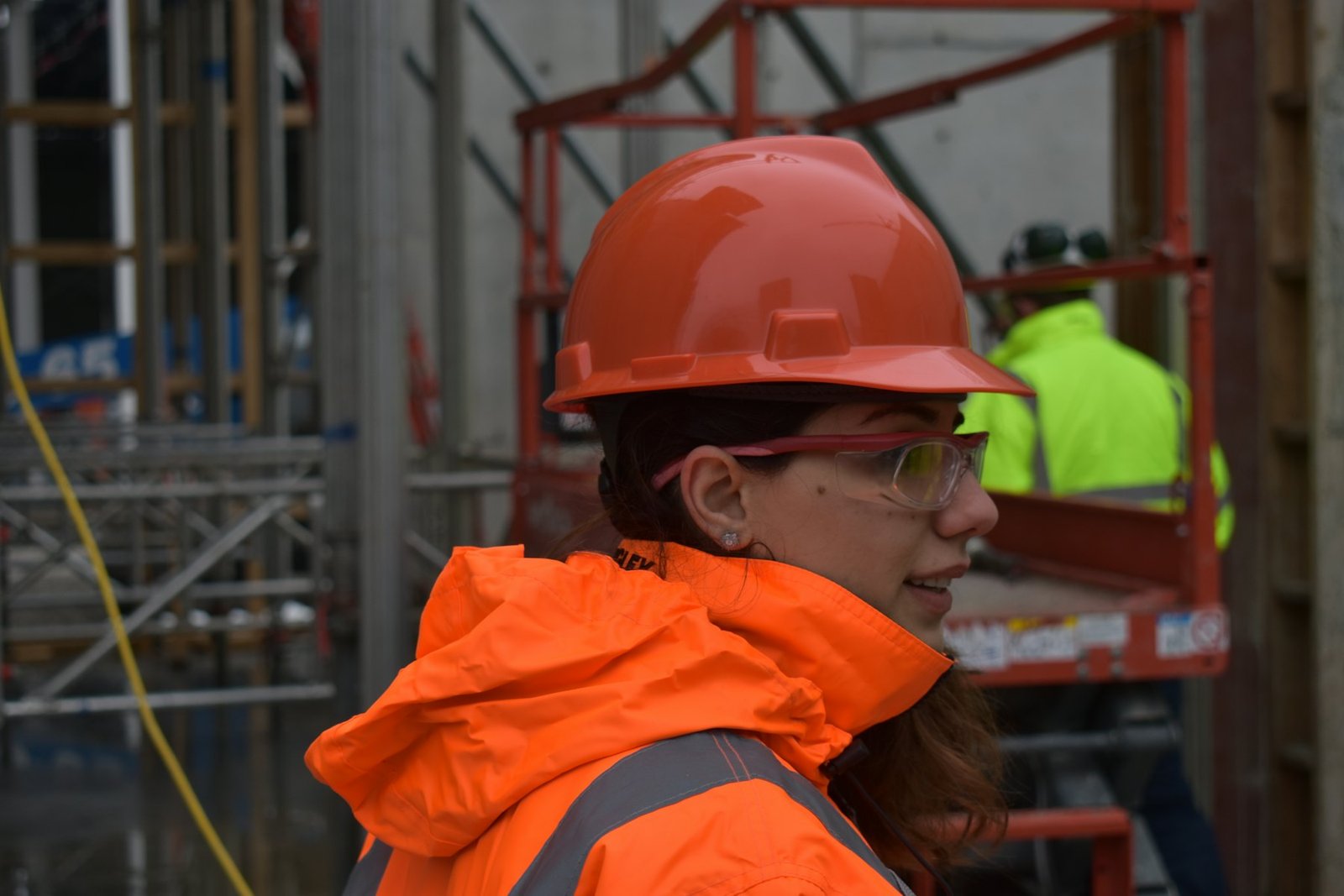 Trabajadora con casco y chaleco reflejante de alta visibilidad